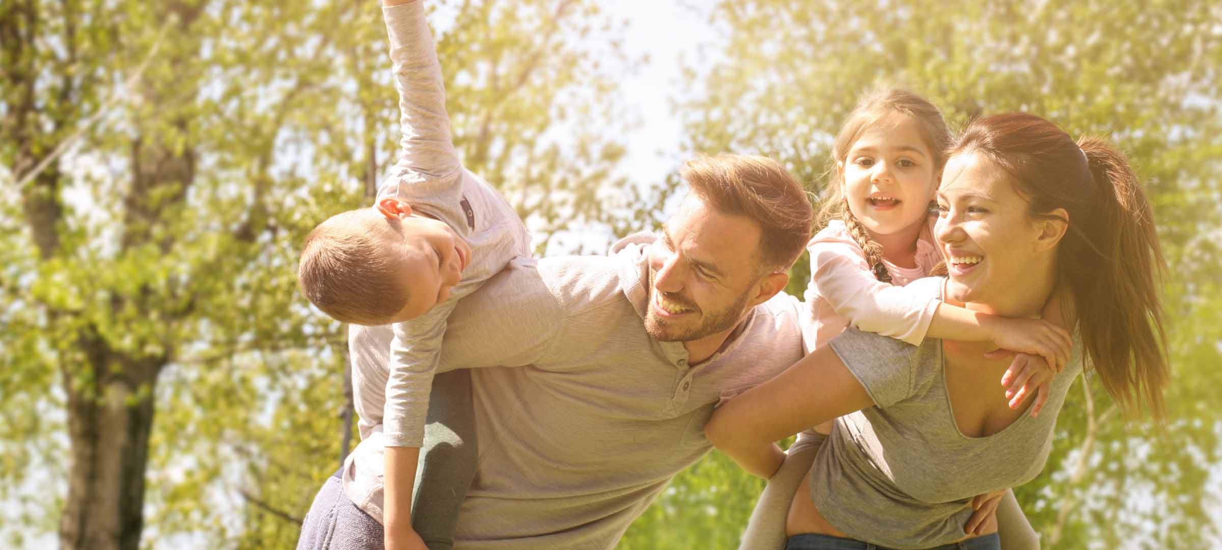 Family of four playing outdoors in sunlit park Family of four playing outdoors in sunlit park - https://www.debreeinsurance.com/contact-us/