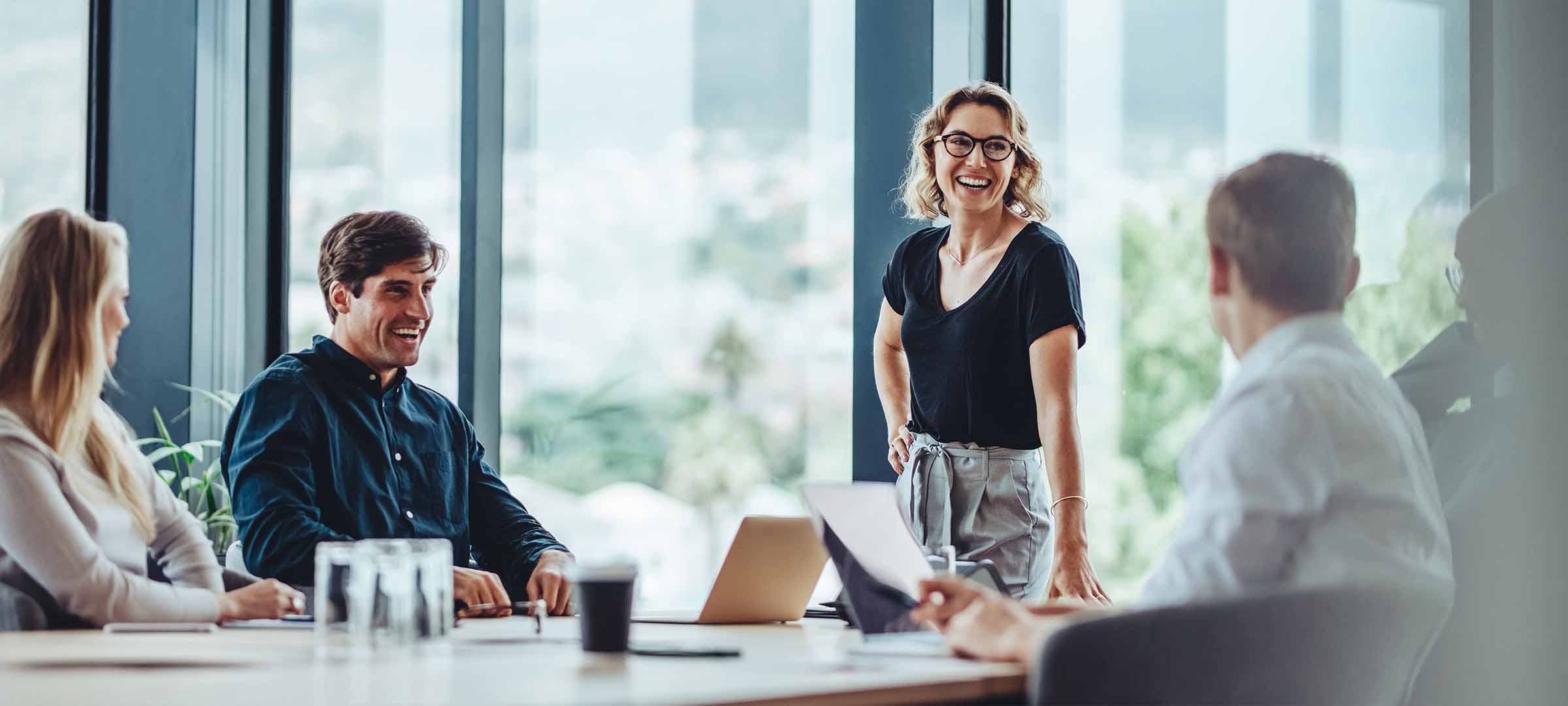 Woman leading a business meeting in a modern conference room with colleagues - https://jamesaryaninsagencyllc.com/