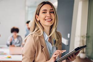 Smiling businesswoman holding a tablet in a modern office. Smiling businesswoman holding a tablet in a modern office.
